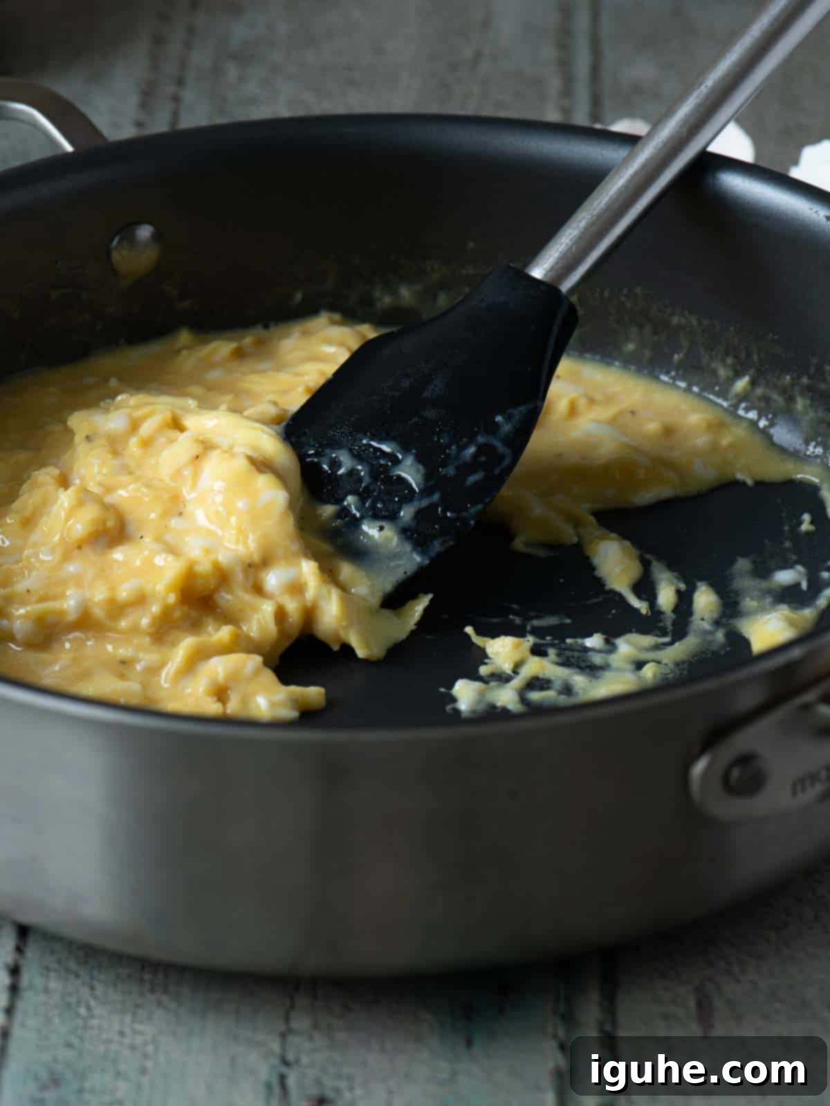 Mediterranean Feta Dill Scramble 6 Scrambled eggs being mixed in a skillet with a spatula.