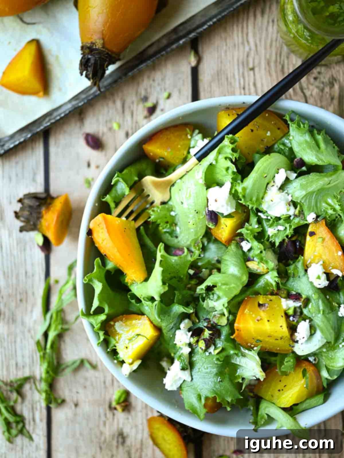 Aromatic Golden Beet Salad with Tarragon Vinaigrette 2 A vibrant golden beet salad with fresh greens, crumbled feta, and pistachios, drizzled with a clear vinaigrette.