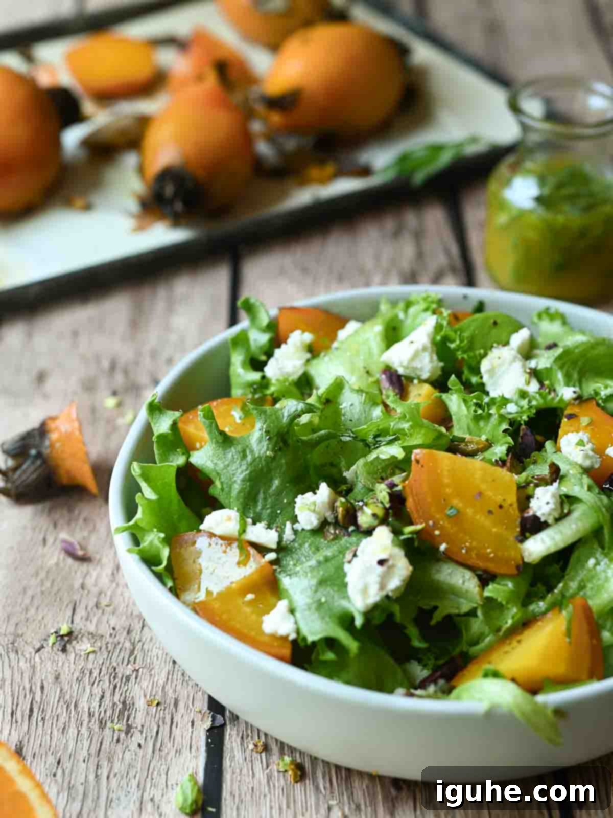 Aromatic Golden Beet Salad with Tarragon Vinaigrette 8 An eye-level view of a colorful golden beet salad in a white bowl, resting on a rustic wooden surface.