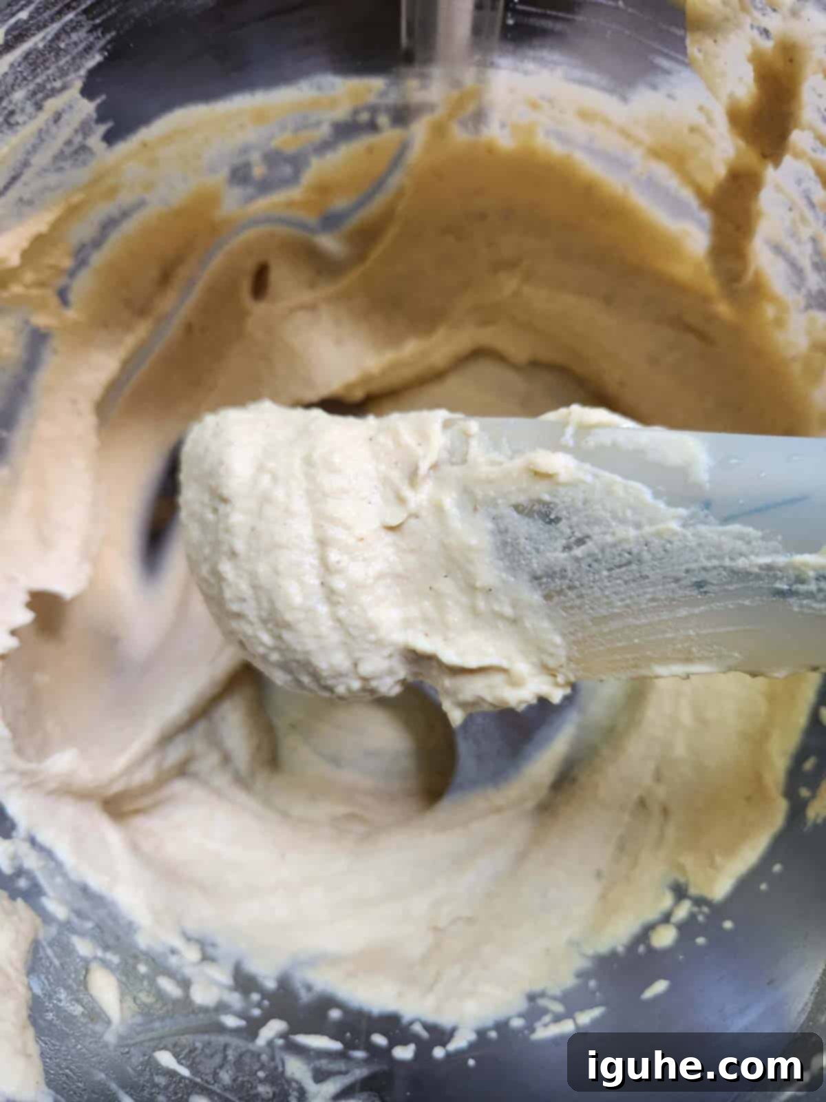 Silken Butter Bean Hummus 5 Blended butter bean hummus in a food processor with a spatula showing the consistency.