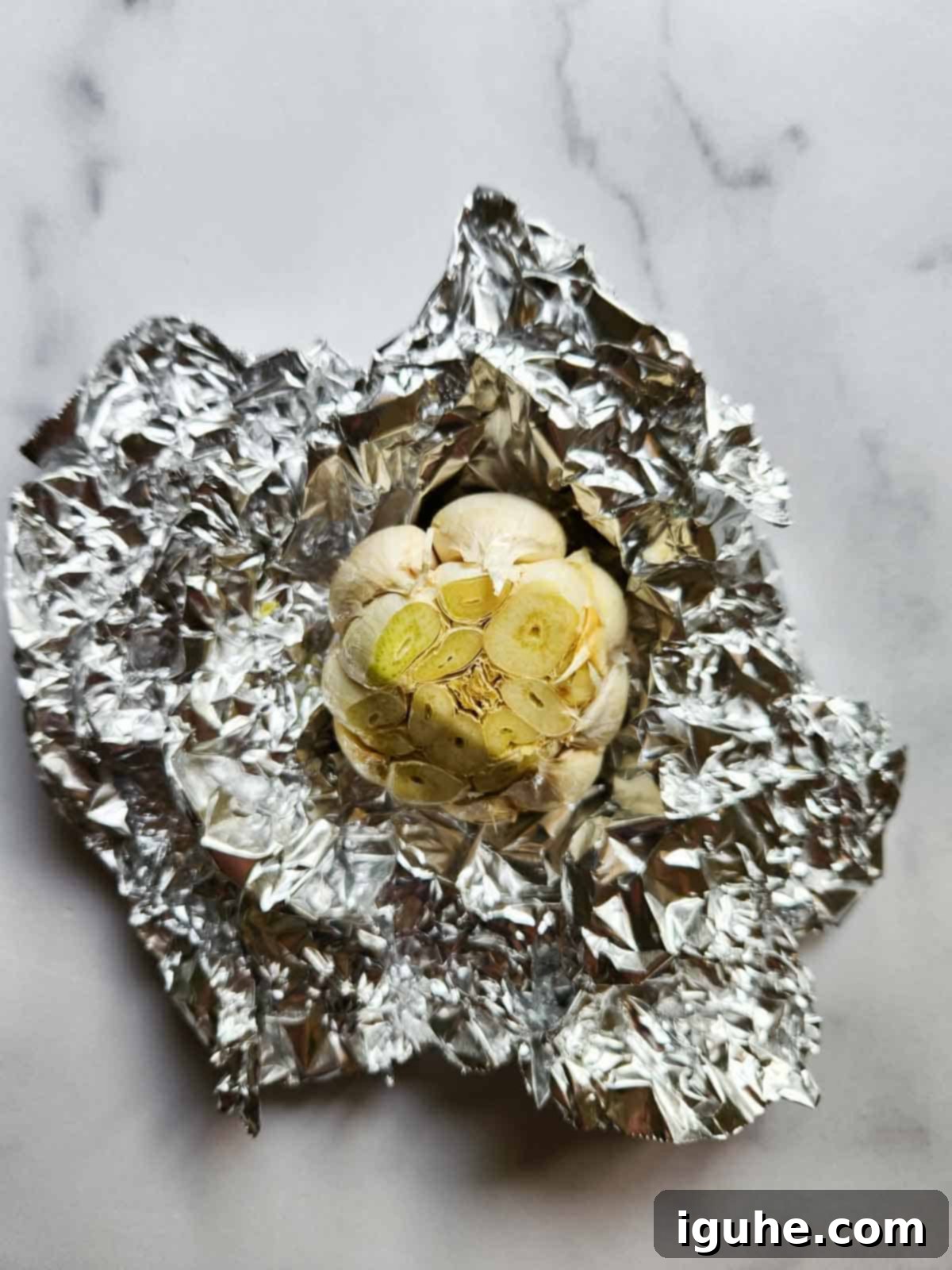 Silken Butter Bean Hummus 6 Raw garlic with top cut in aluminum foil.