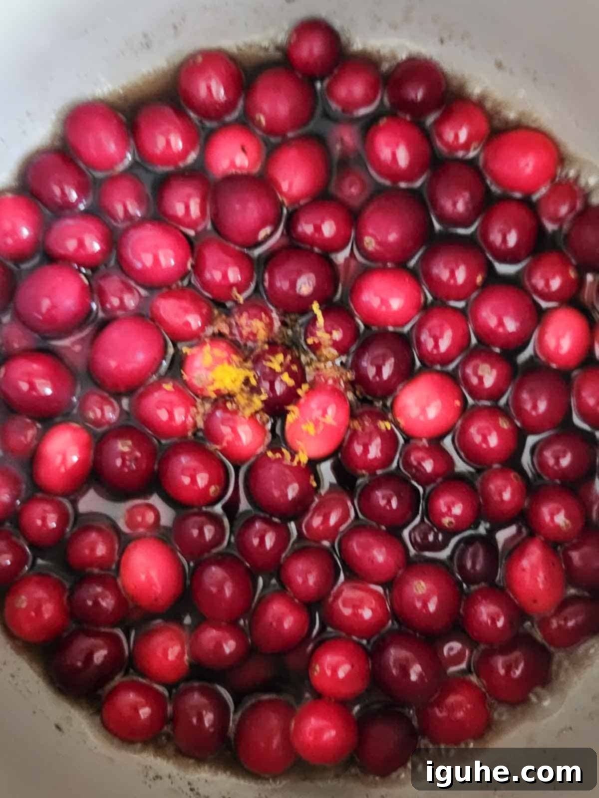 Luscious Vanilla Cranberry Compote 5 Fresh cranberries and orange zest added to the simmering sugar syrup in a pot.