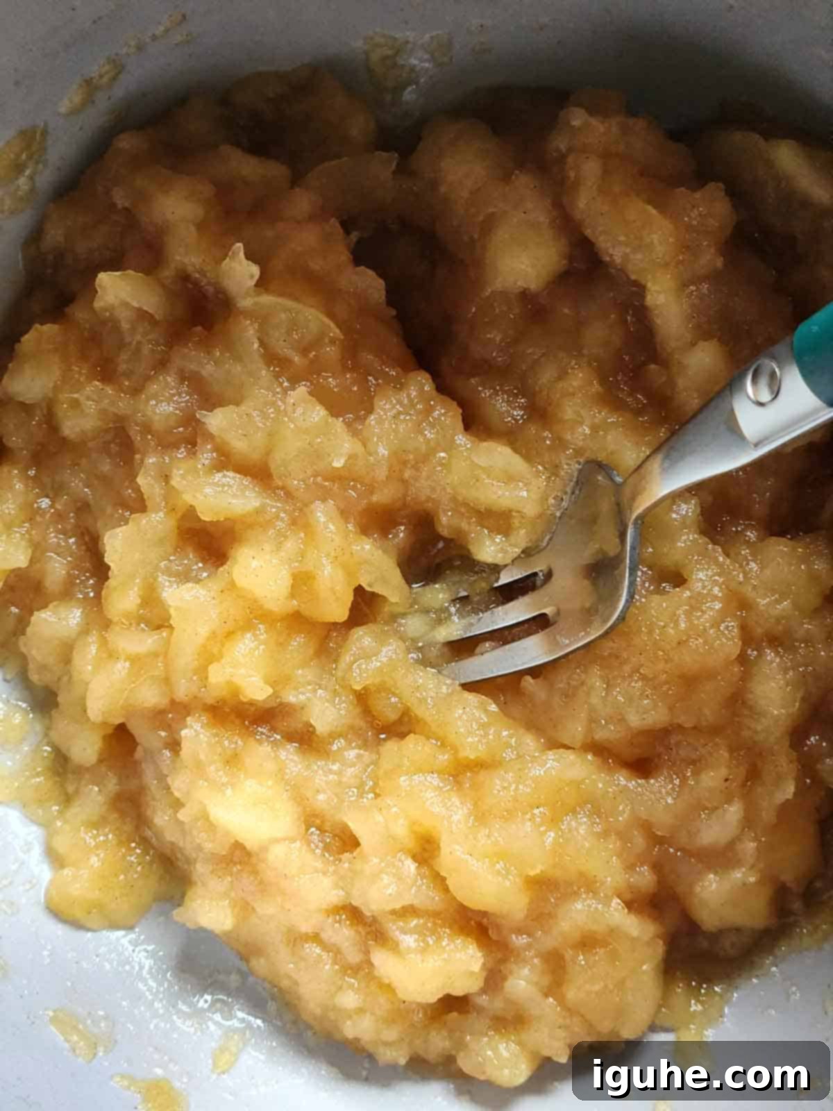Spiced Honeycrisp Applesauce 7 A fork in a pot after mashing apples for applesauce.
