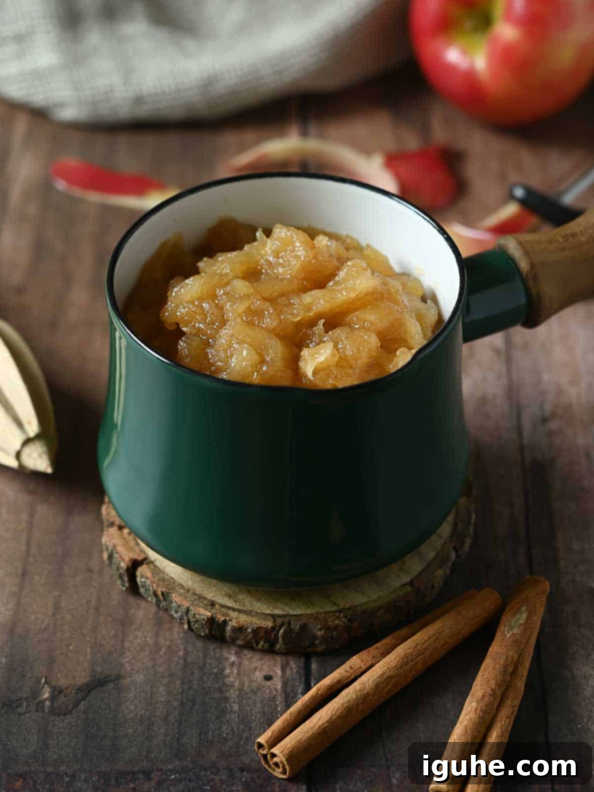 Spiced Honeycrisp Applesauce 9 Applesauce in a small green pot on a wood table.
