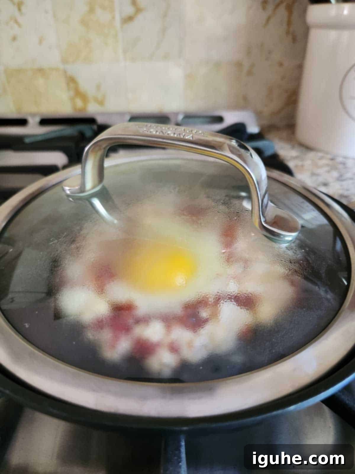 Sun-Kissed Feta and Tomato Fried Eggs 6 A non-stick skillet covered with a lid on the stove, gently steaming, ensuring the egg and feta cook evenly to perfection.