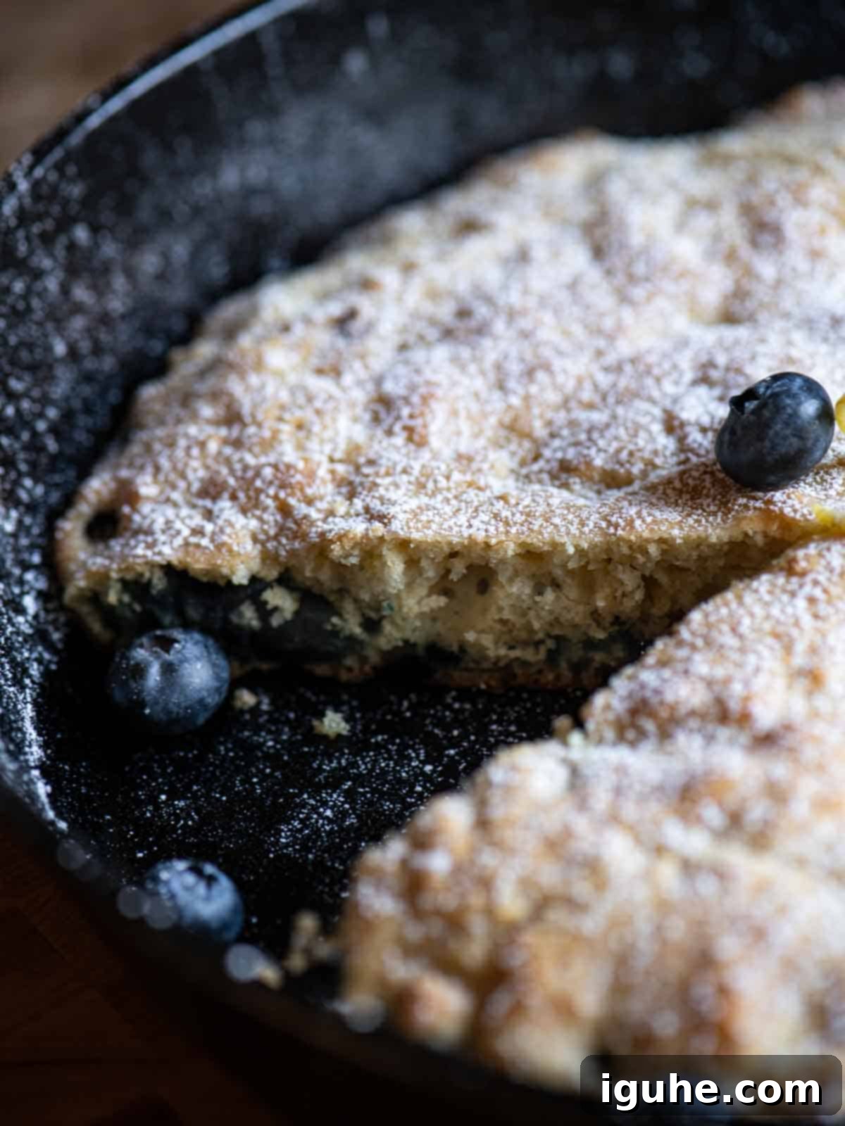 Blueberry Burst Skillet Pancake 11 Close-up of a skillet pancake with a slice taken out.