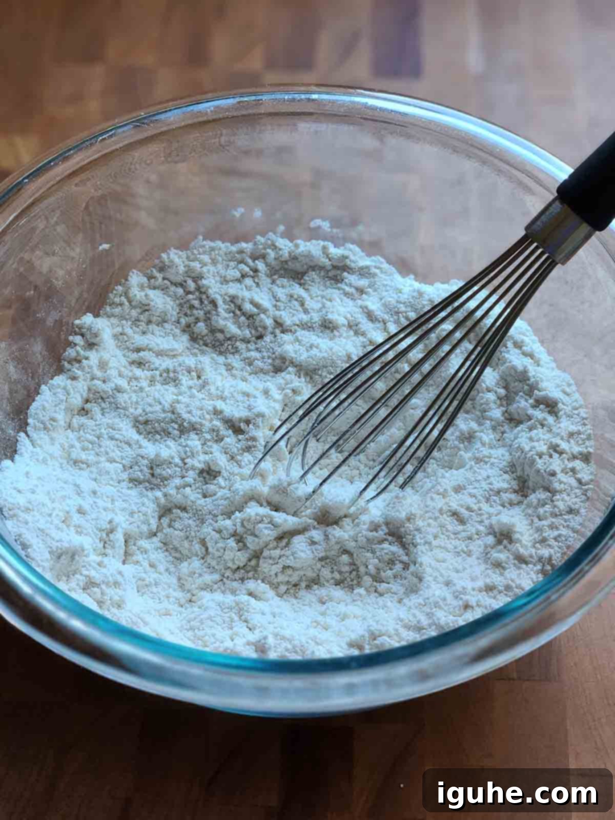 Blueberry Burst Skillet Pancake 4 Dry ingredients in a clear bowl with a whisk.
