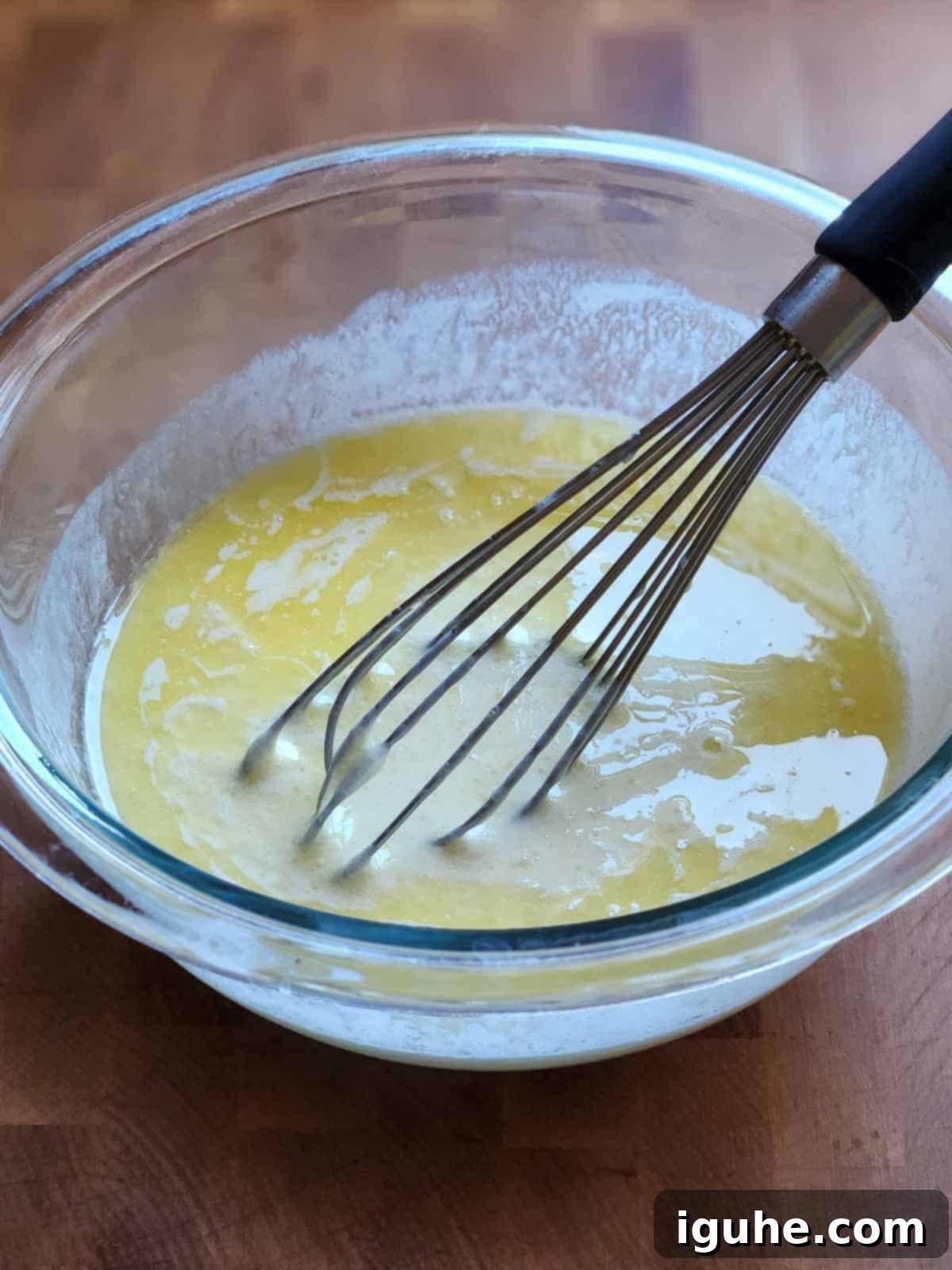 Blueberry Burst Skillet Pancake 5 Wet ingredients in a clear bowl with a whisk.