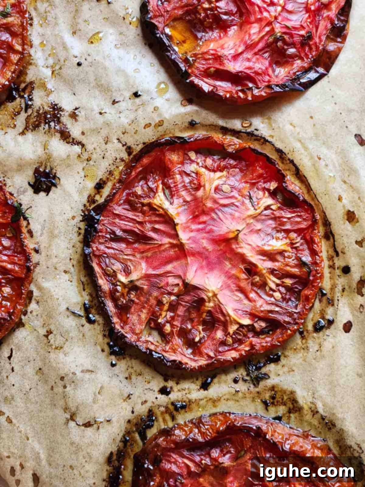 Sweet & Savory Slow Roasted Beefsteak Tomatoes 5 Overhead of roasted beefsteak tomatoes on brown parchment paper.