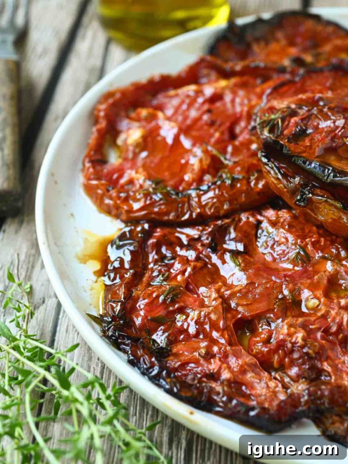 Sweet & Savory Slow Roasted Beefsteak Tomatoes 6 Close-up of roasted tomatoes with oil and thyme.