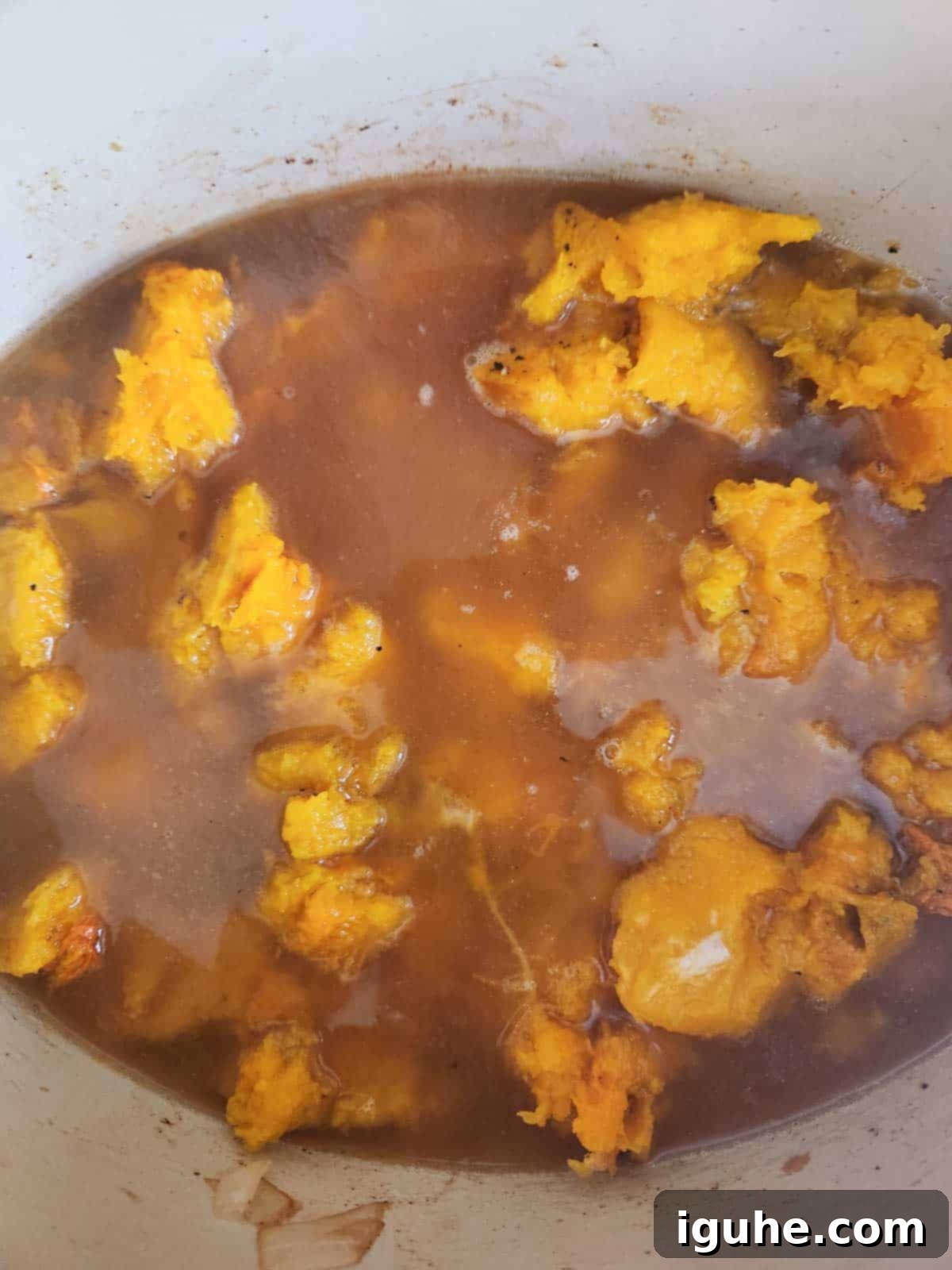Golden Harvest Squash Soup 7 Roasted squash flesh added to a pot with sautéed vegetables and chicken stock, ready to simmer.