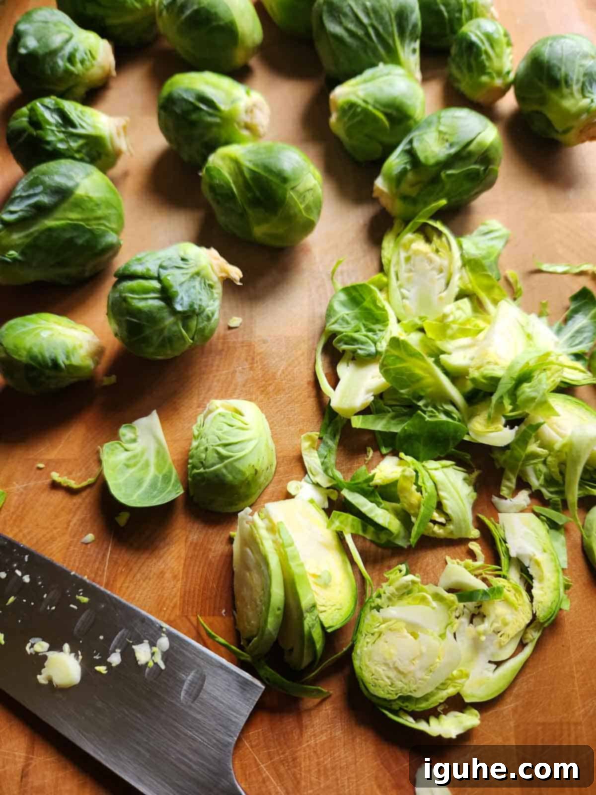 Crispy Sprout Skillet 4 Brussel sprouts on a cutting board with a knife to the left.