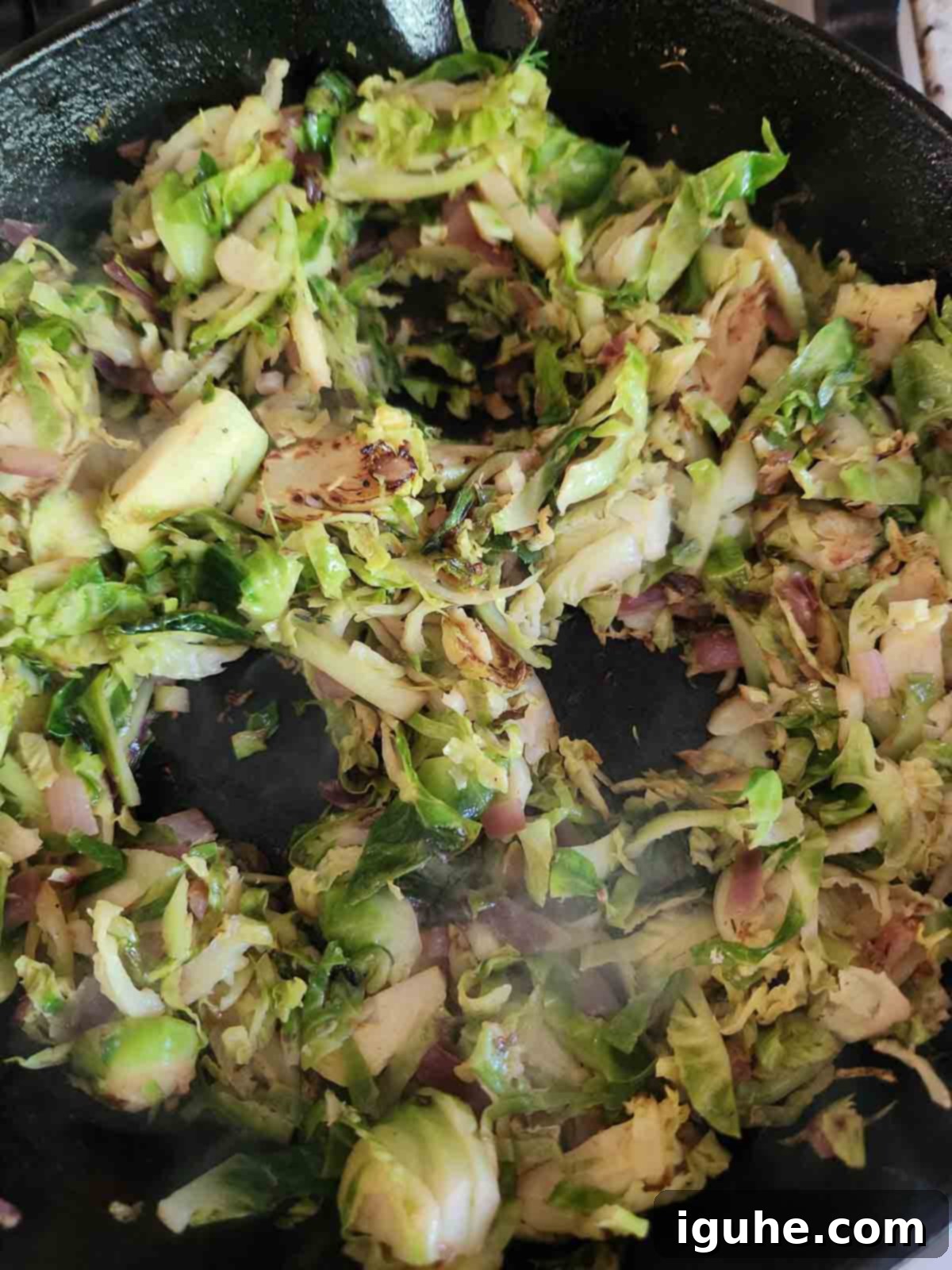 Crispy Sprout Skillet 8 Brussel sprout hash in a skillet with 3 holes in it for eggs.