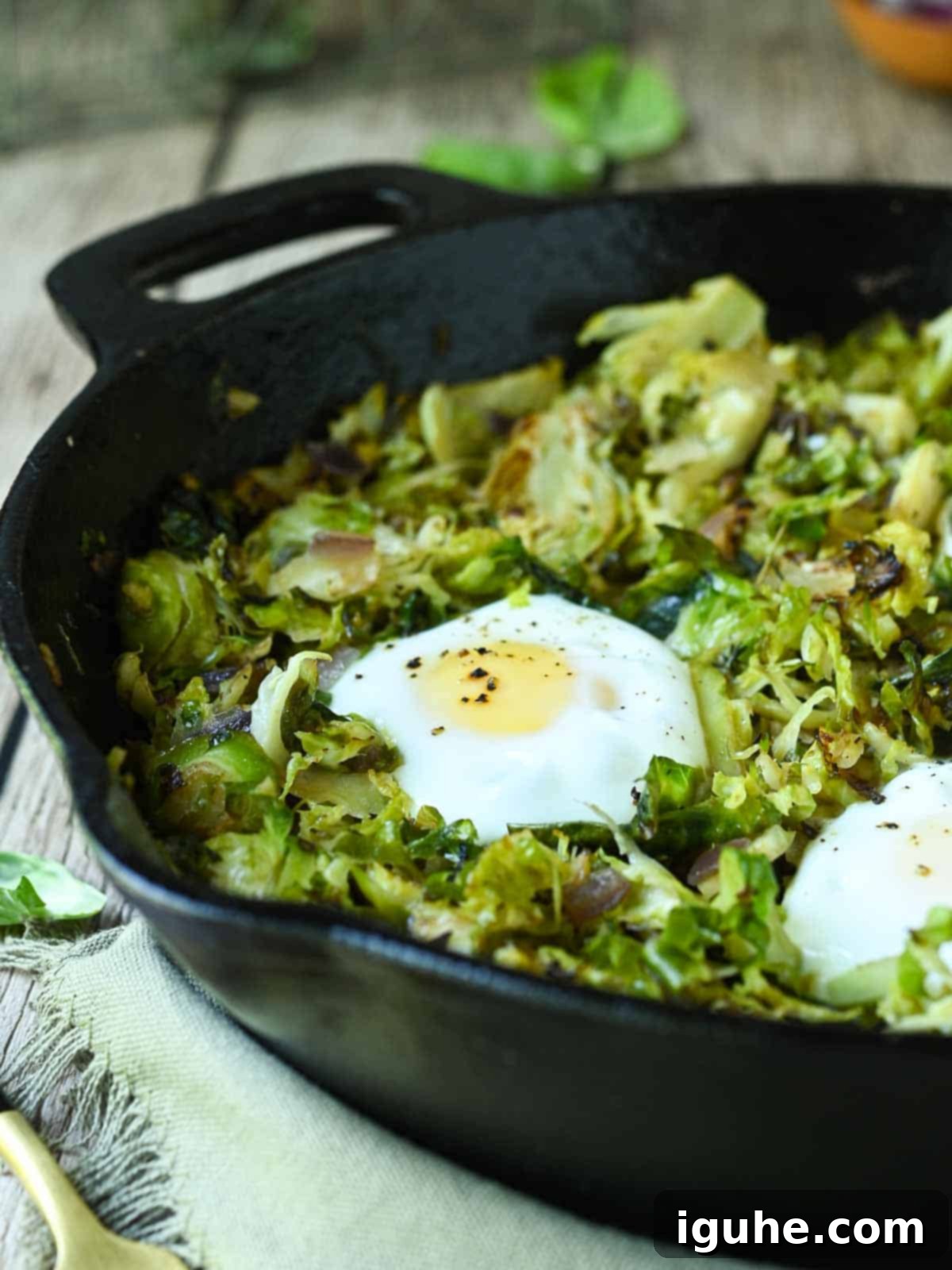 Crispy Sprout Skillet 10 Brussel sprout hash in a black skillet with eggs.