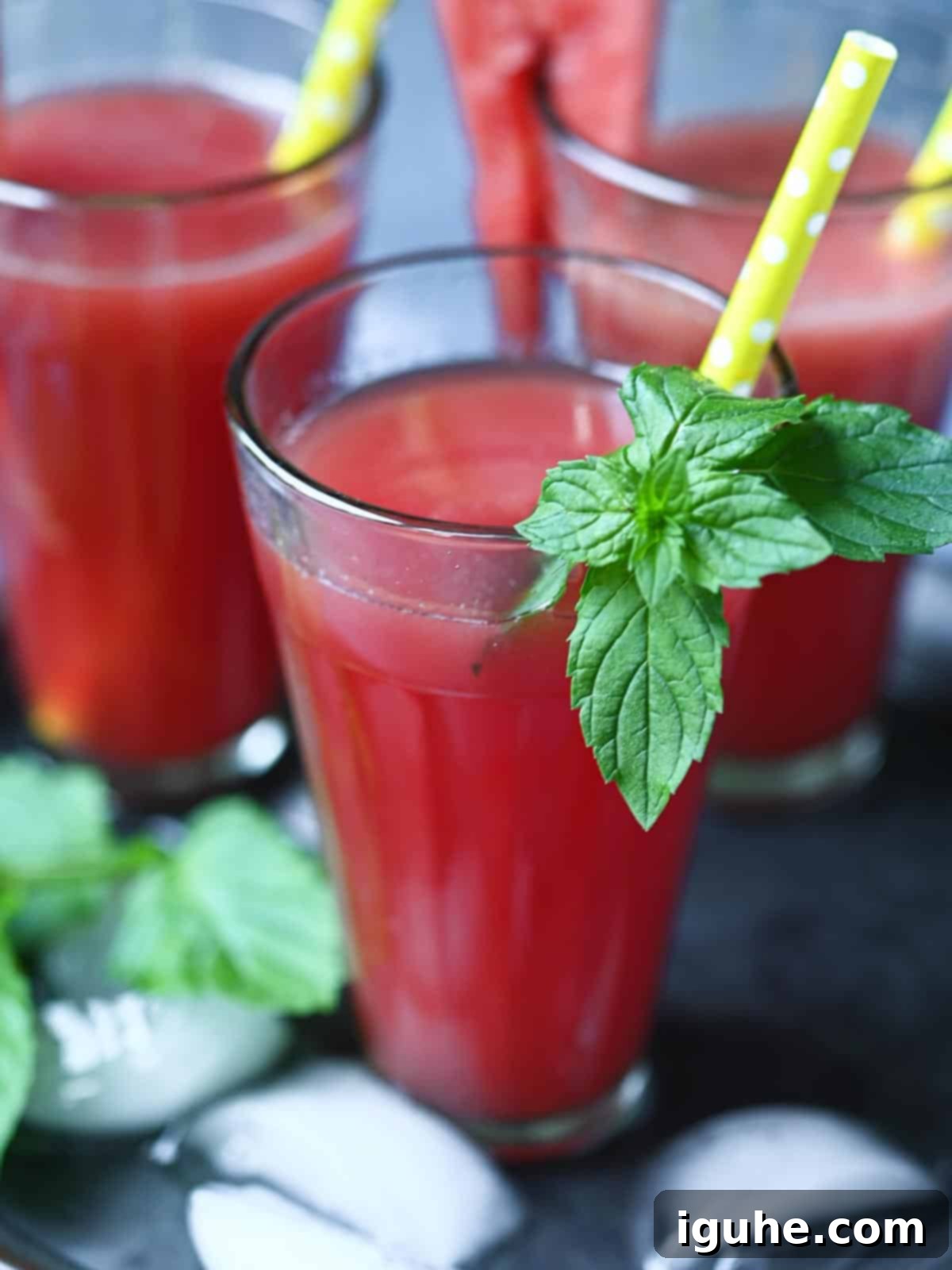Pure Watermelon Refreshment 7 Close-up of a refreshing glass of watermelon water with mint leaves and a yellow straw.
