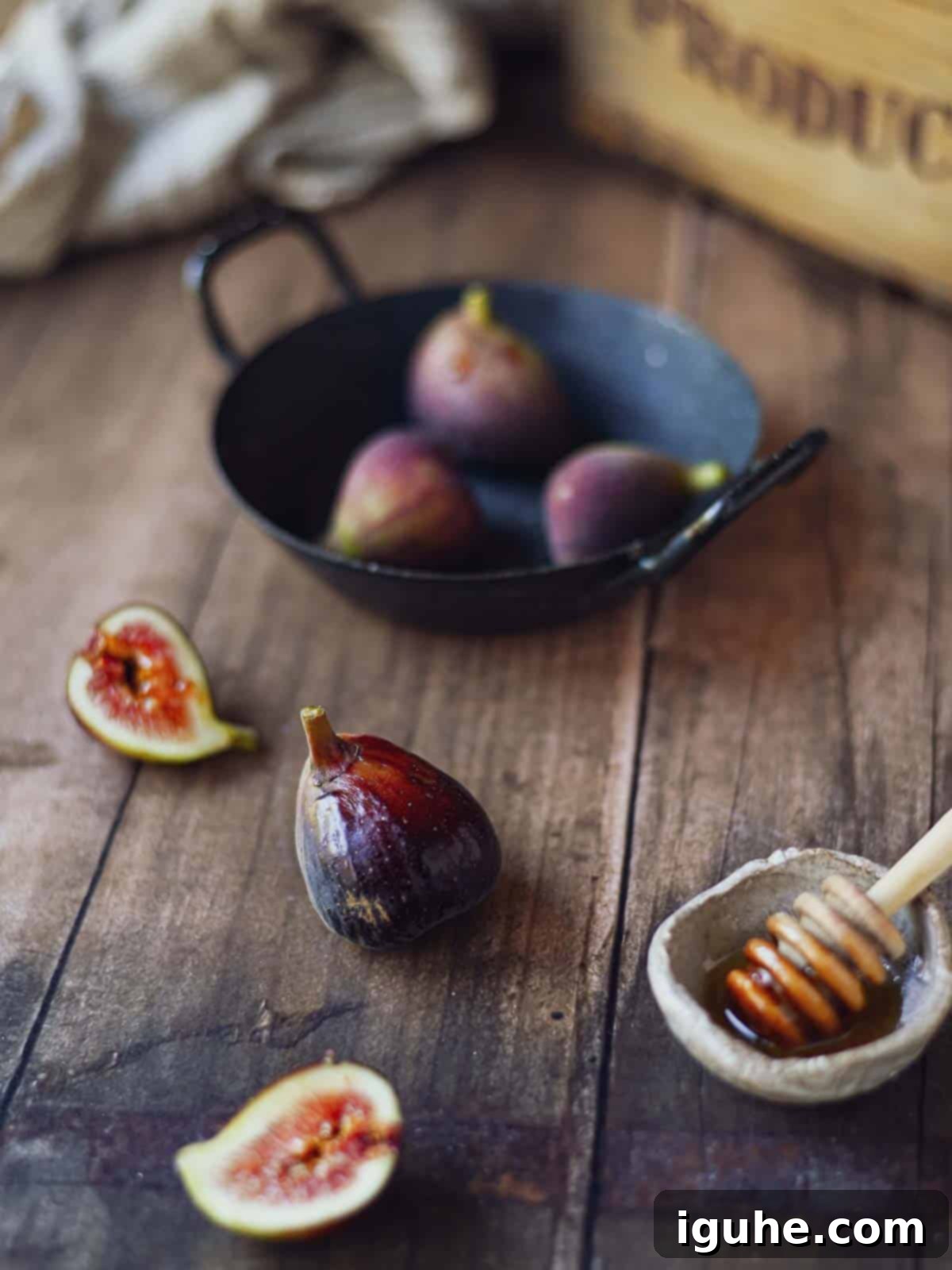 Sweet and Savory Balsamic Fig Toast 3 Fresh figs with rosemary and balsamic vinegar in a roasting pan on a rustic wood surface.