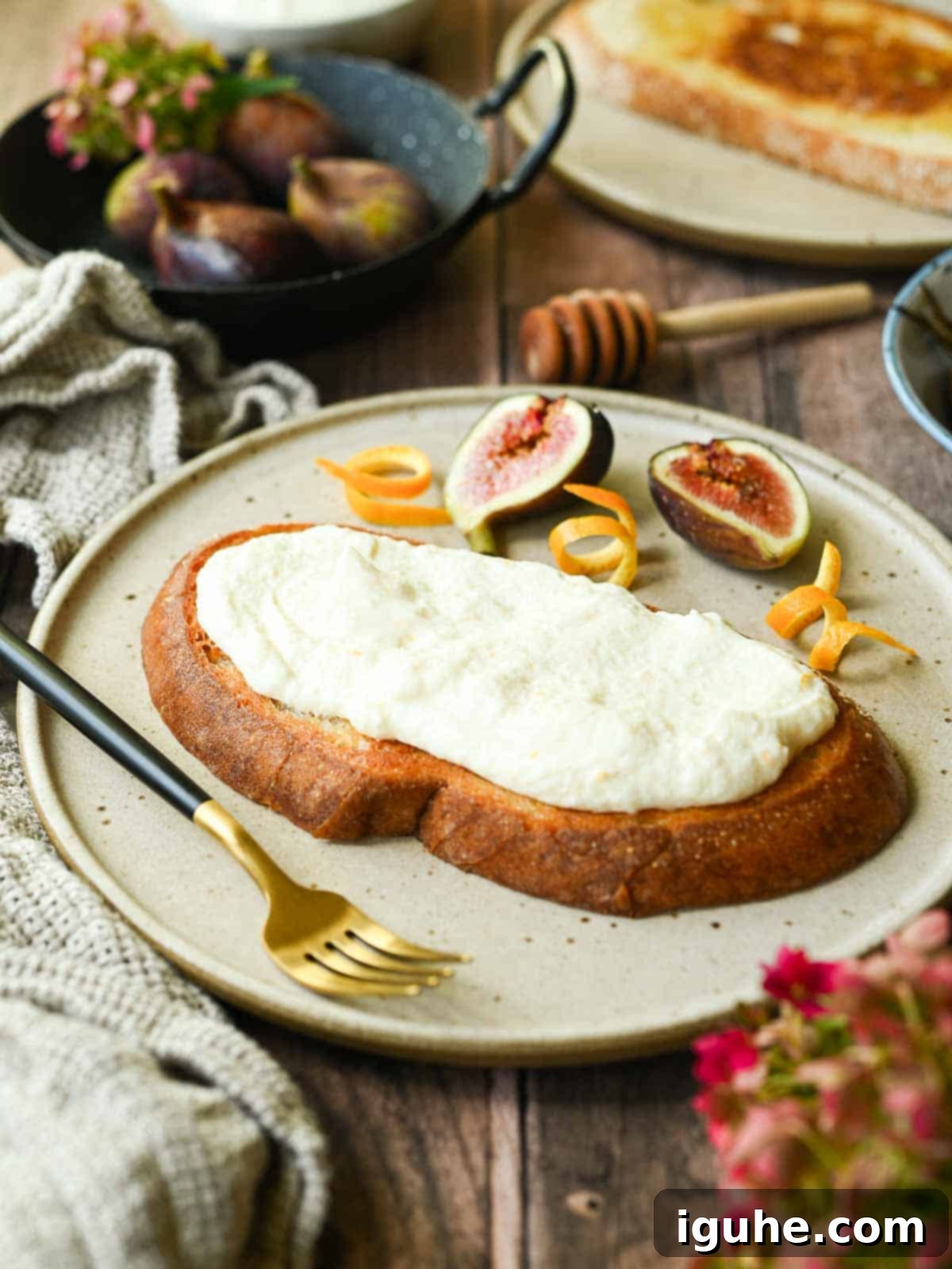 Sweet and Savory Balsamic Fig Toast 6 Thick toasted bread slices topped with creamy whipped ricotta cheese on a beige plate.
