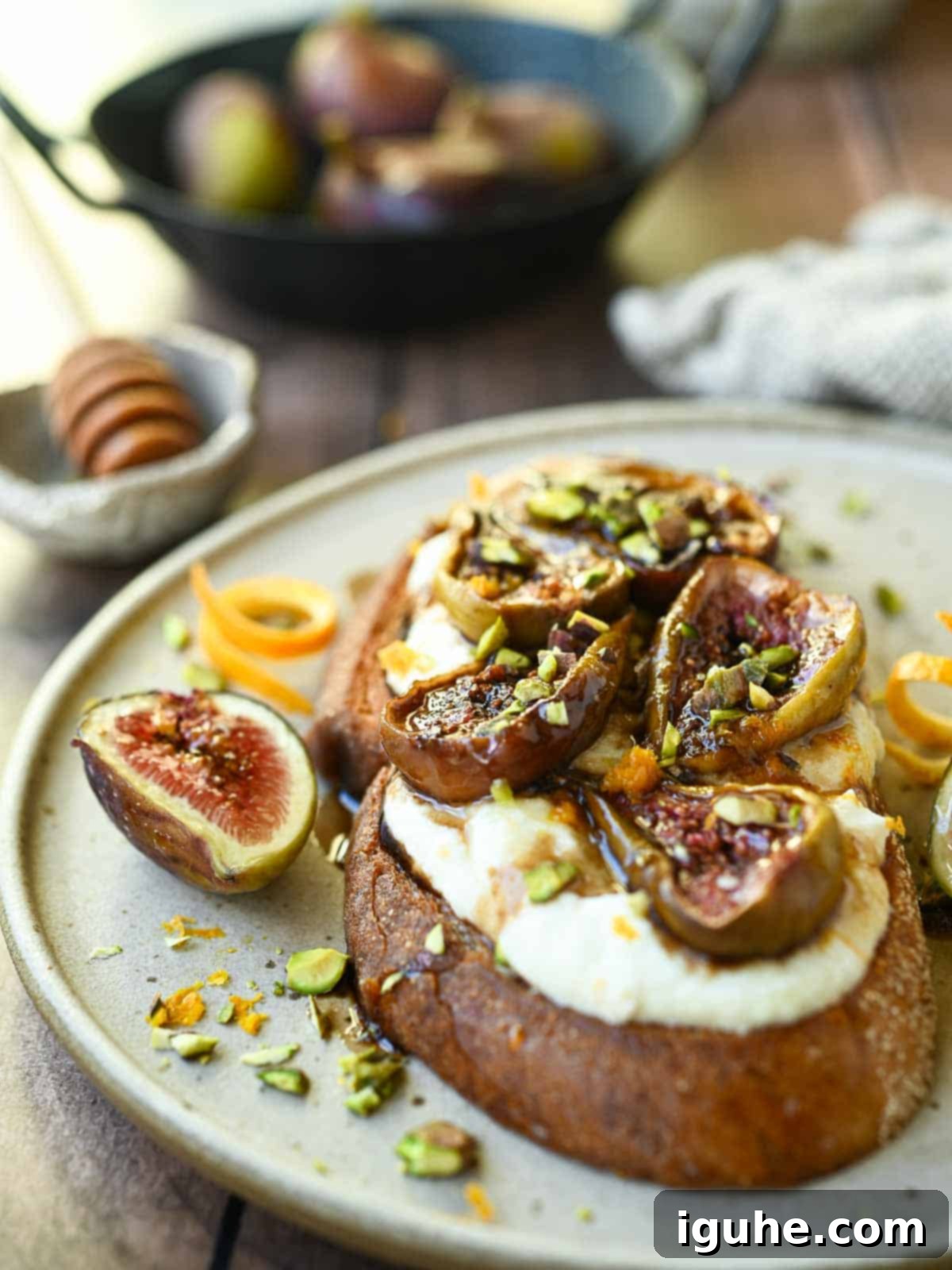 Sweet and Savory Balsamic Fig Toast 9 Eye-level view of balsamic fig toast on a brown plate, showcasing its layers.