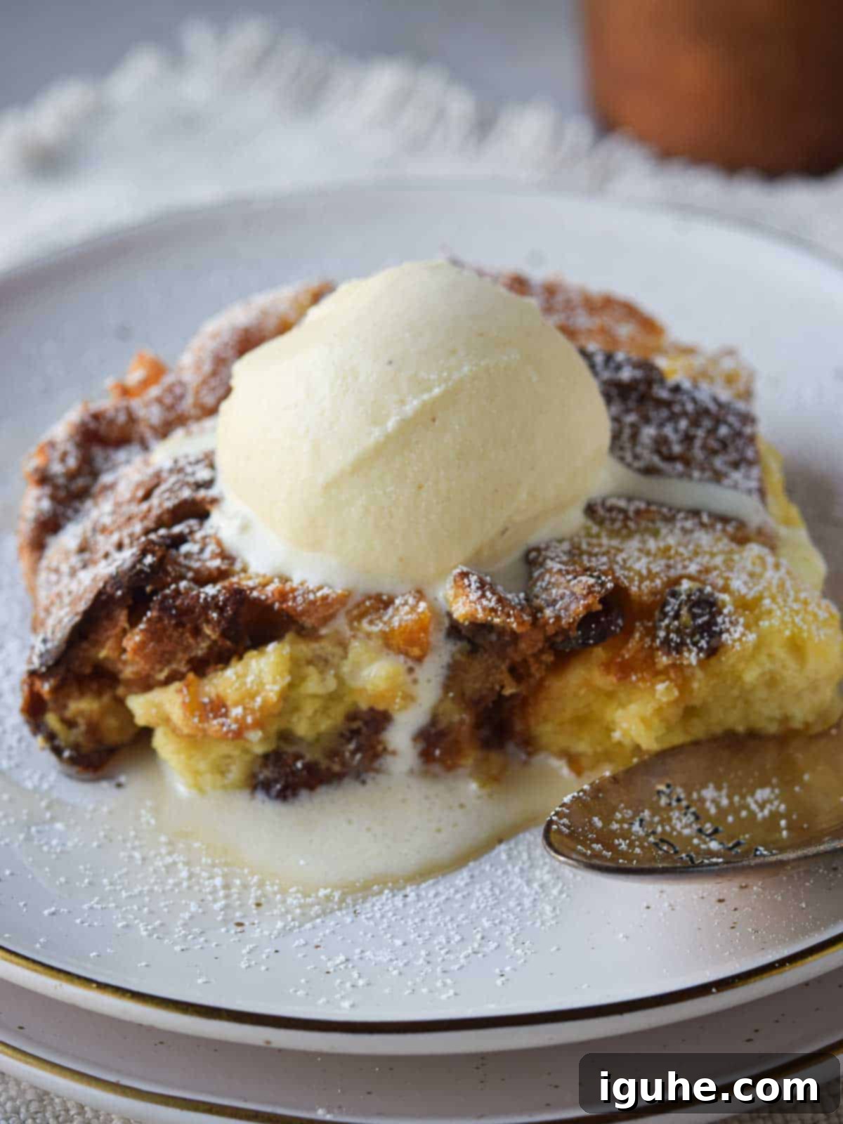 Italian Panettone Bread Pudding 8 Close-up of panettone bread pudding with a scoop of vanilla ice cream on top.