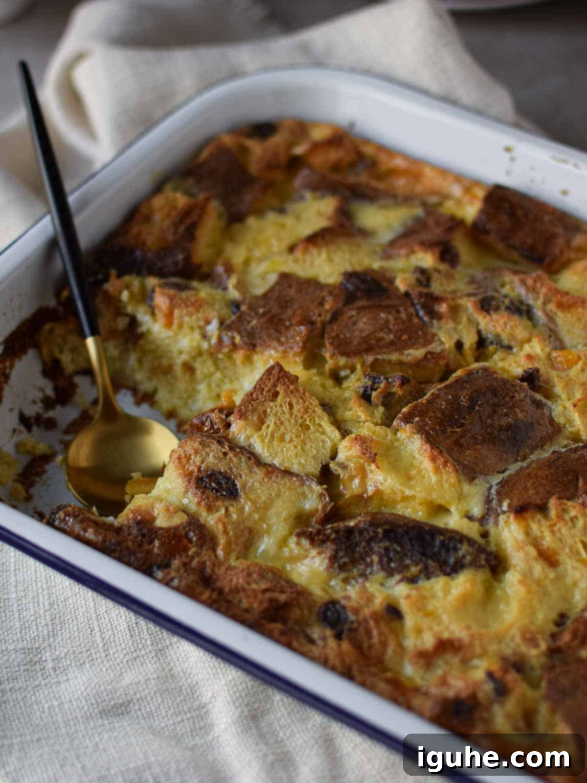 Italian Panettone Bread Pudding 9 Panettone bread pudding in a large baking pan with a slice taken out.