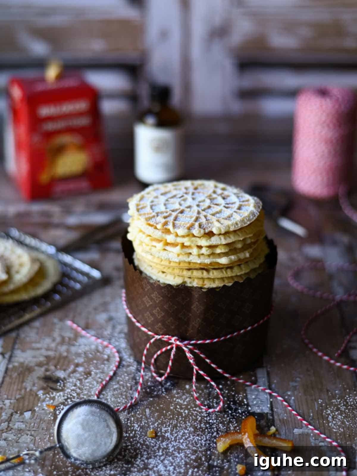 Angled view of panettone pizzelle in a wrapper with bakers string around it.