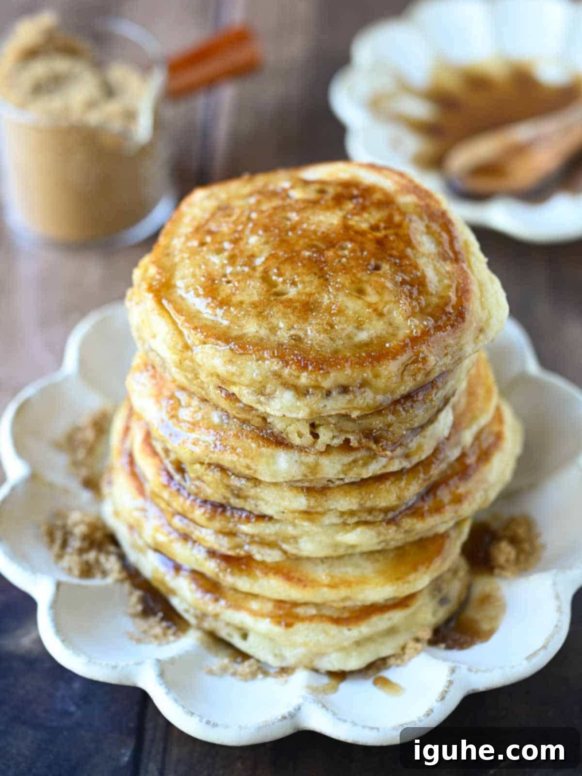 Decadent Brown Sugar Stacks 2 Brown sugar pancakes stacked on a beige plate, drizzled with brown sugar syrup and a pat of butter.
