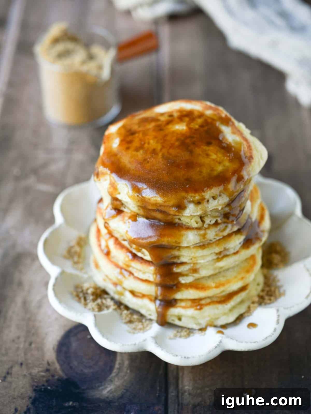 Decadent Brown Sugar Stacks 8 Brown sugar syrup dripping lusciously down a tall stack of golden-brown pancakes, garnished with a pat of butter.