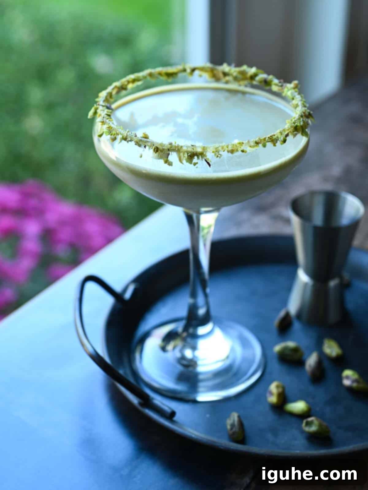 Velvet White Chocolate Pistachio Martini 3 White chocolate pistachio martini backlight by a window.