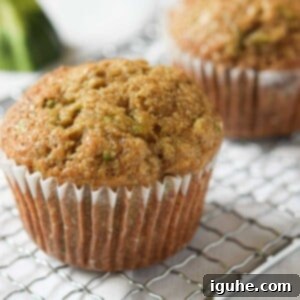 Apple-Kissed Zucchini Muffins 12 Close up of a zucchini muffin on a metal rack.