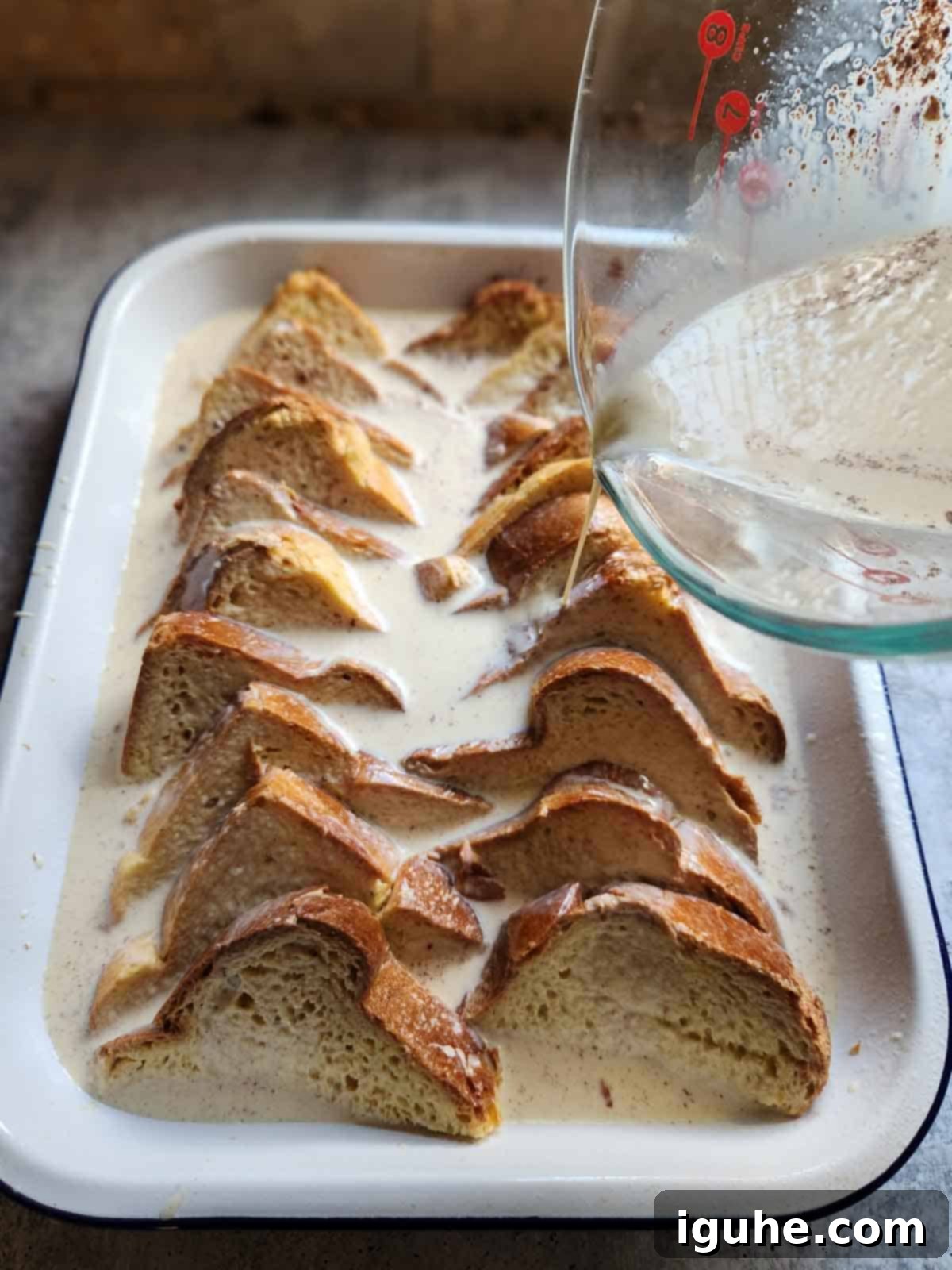 Decadent Baked Brioche French Toast 7 Remaining custard being poured over bread for Baked Brioche French Toast.
