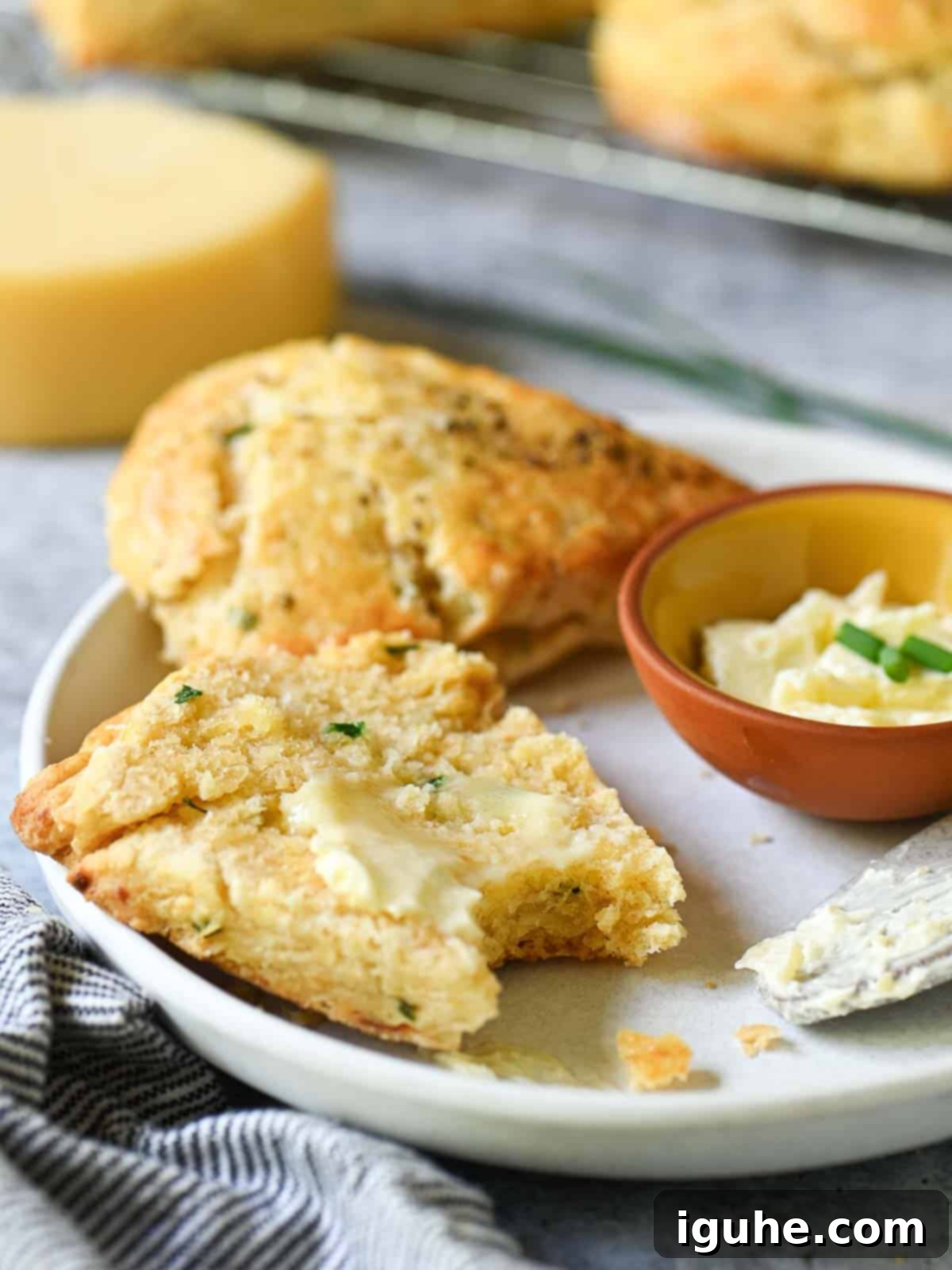 Savory Smoked Gouda and Chive Scones 9 Split scone with melted butter on a white plate.