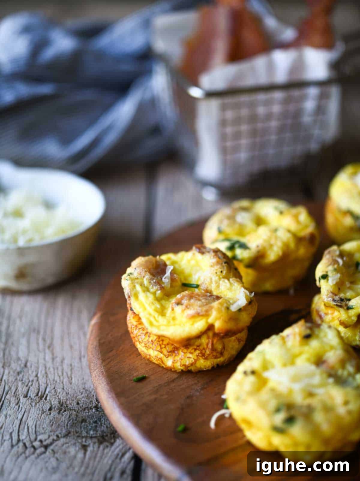Bacon Buttermilk Egg Bites 3 Egg bites on a wood board with bacon and cheese.