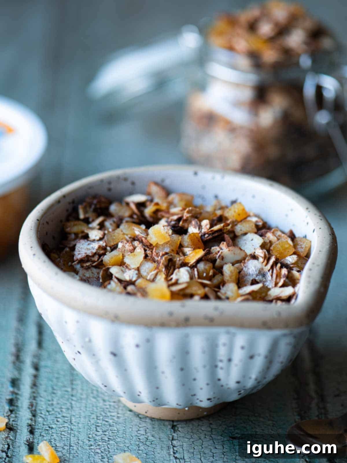 Candied Orange Chocolate Muesli 9 Chocolate muesli in a bowl on a blue surface, ready to be enjoyed.