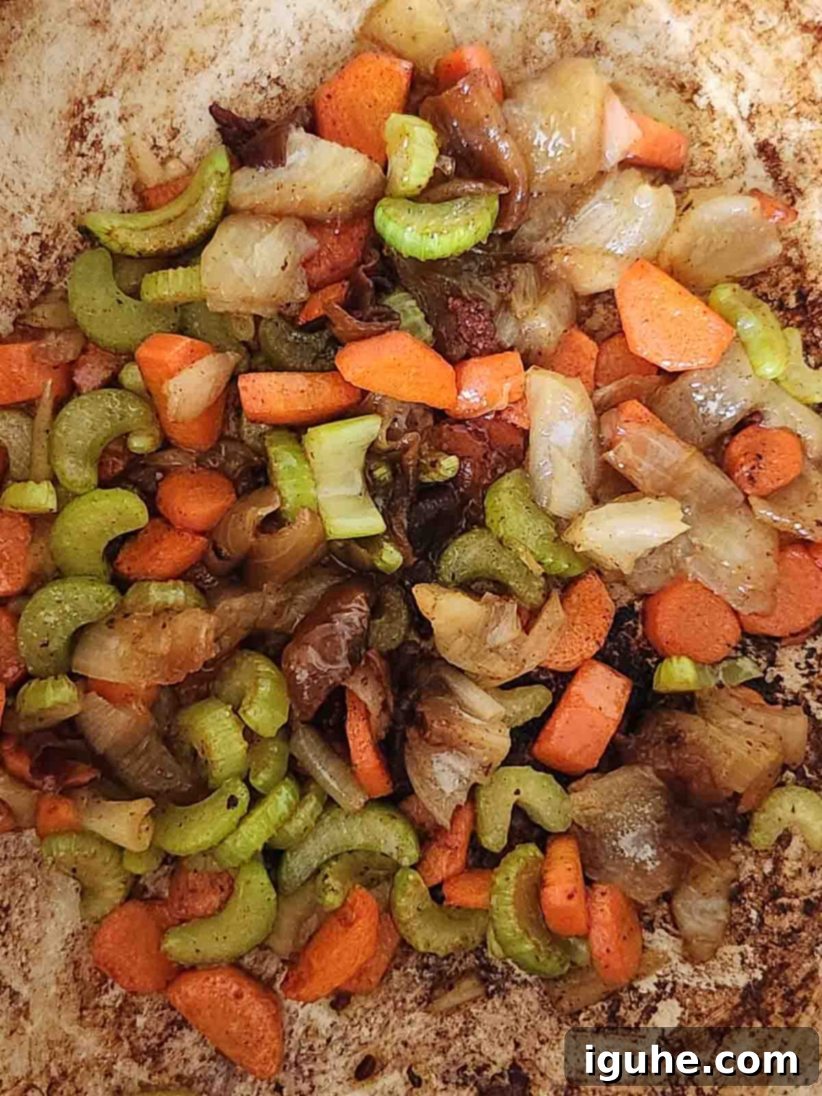 Hearty Bacon Lentil Soup 5 Diced carrots, celery, and onion (mirepoix) sautéing in a pot with rendered bacon fat, forming the aromatic base for the soup.