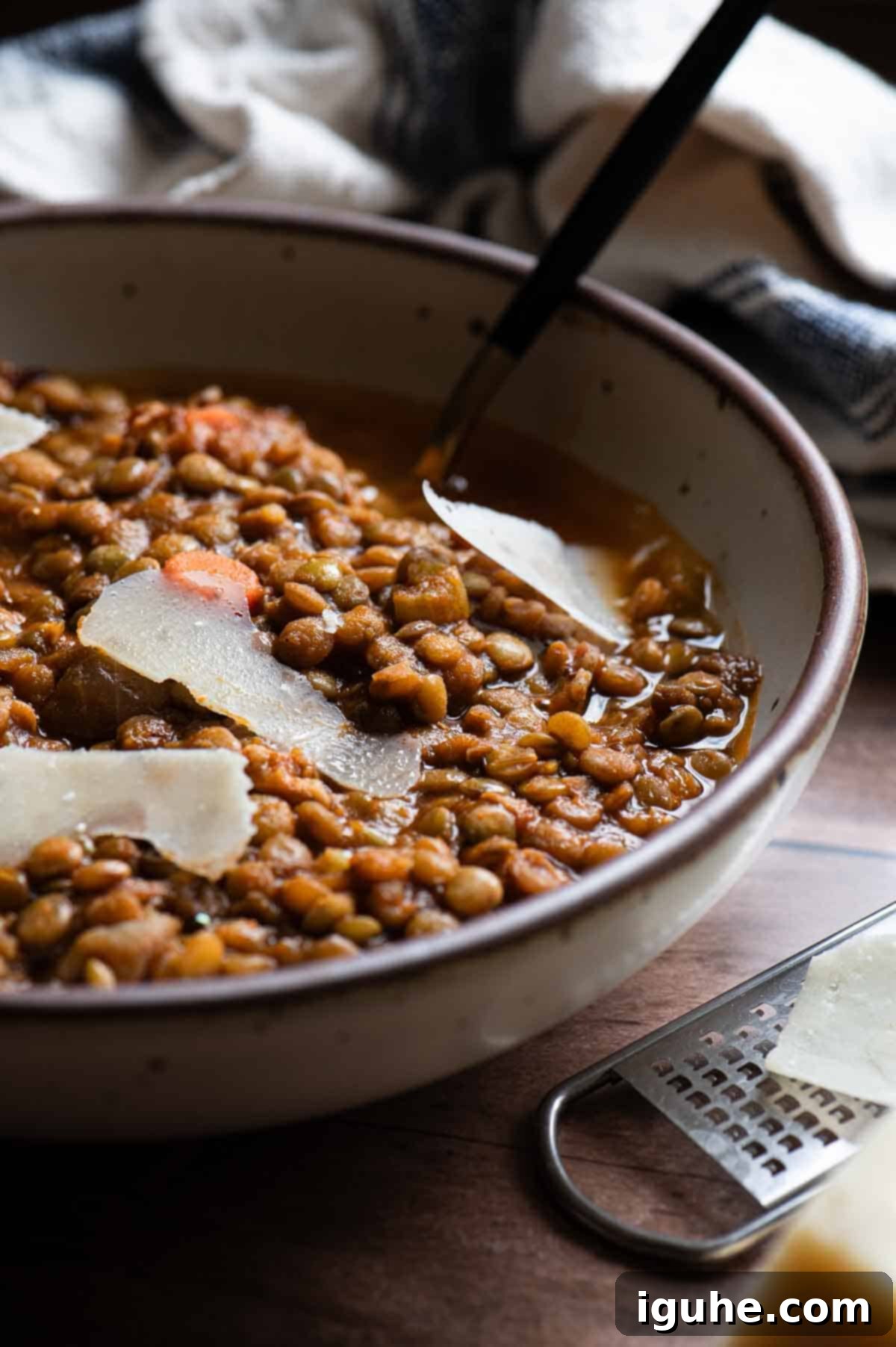 Hearty Bacon Lentil Soup 10 Close-up of hearty bacon lentil soup served in a rustic beige bowl, garnished with fresh herbs and a drizzle of olive oil, emphasizing its rich texture and inviting warmth.