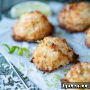 Tropical Coconut Lime Macaroons 12 Coconut macaroons on a wire rack with lime zest and coconut around it.