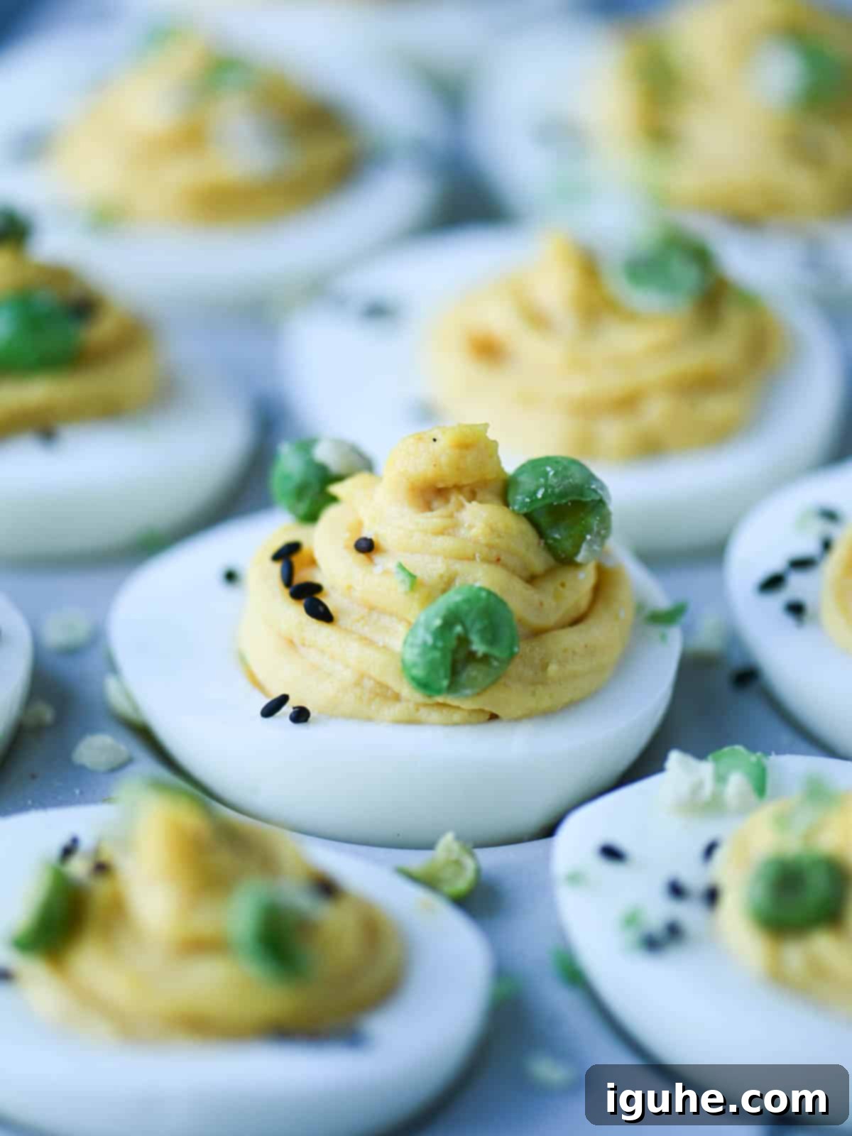 Umami Deviled Eggs 2 Close-up of miso deviled eggs with wasabi peas on top.