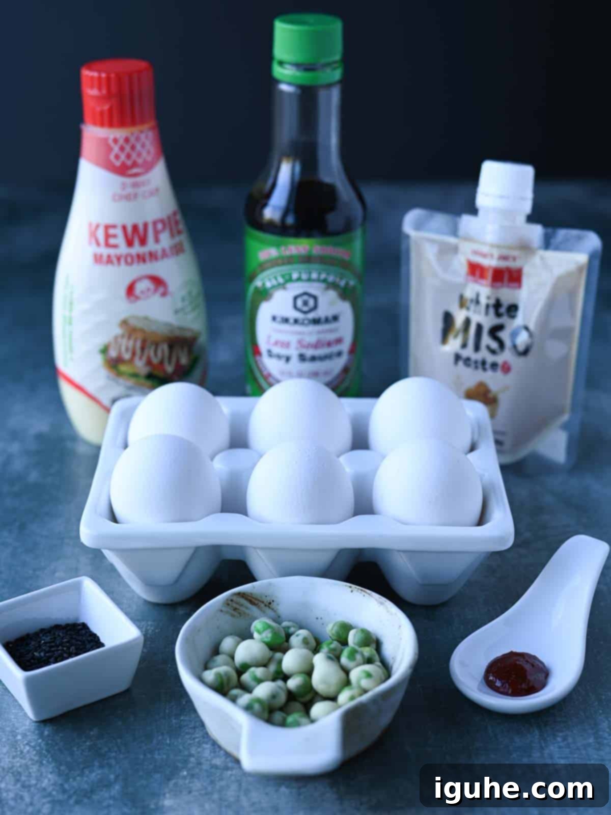 Umami Deviled Eggs 3 Ingredients for miso deviled eggs on a blue surface.