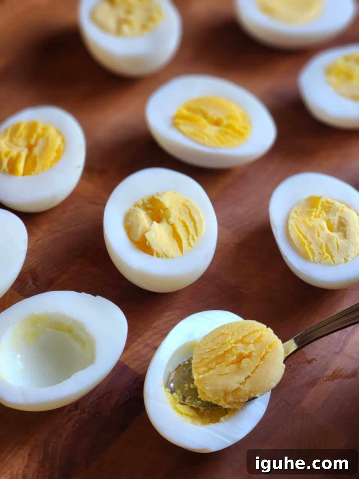 Umami Deviled Eggs 6 Yolks being removed from hard boiled eggs.