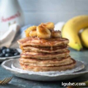 Homemade Banana Bread Pancakes with Banana Compote 8 A close up of a stack of fluffy banana bread pancakes with a generous serving of homemade banana compote on top, ready to be enjoyed.