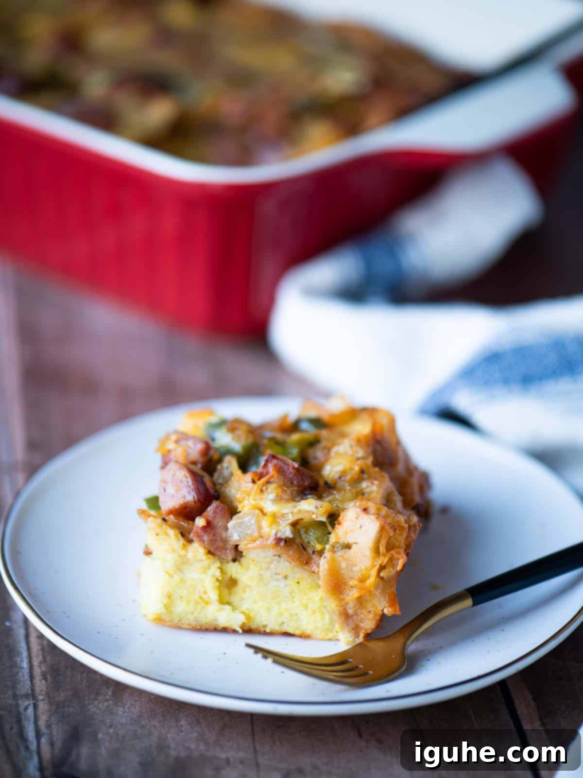 Smoked Sausage Casserole 7 A slice of strata on a plate with a fork to the right.
