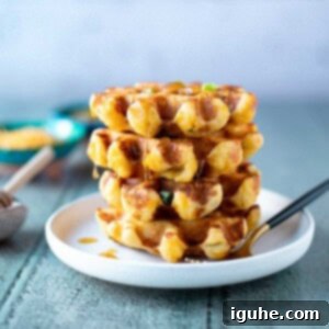 Zesty Cheddar Chili Waffles 8 Stack of green chili cheddar waffles with honey dripping down them.