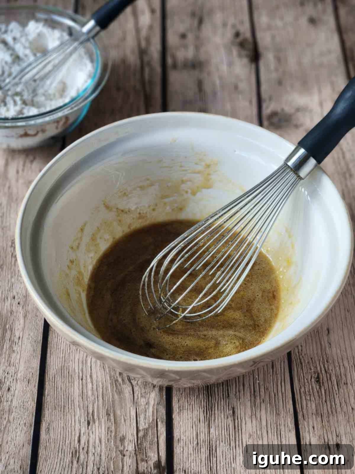 Golden Chocolate Chip Loaf 5 Wet ingredients in a large mixing bowl with a whisk in it.