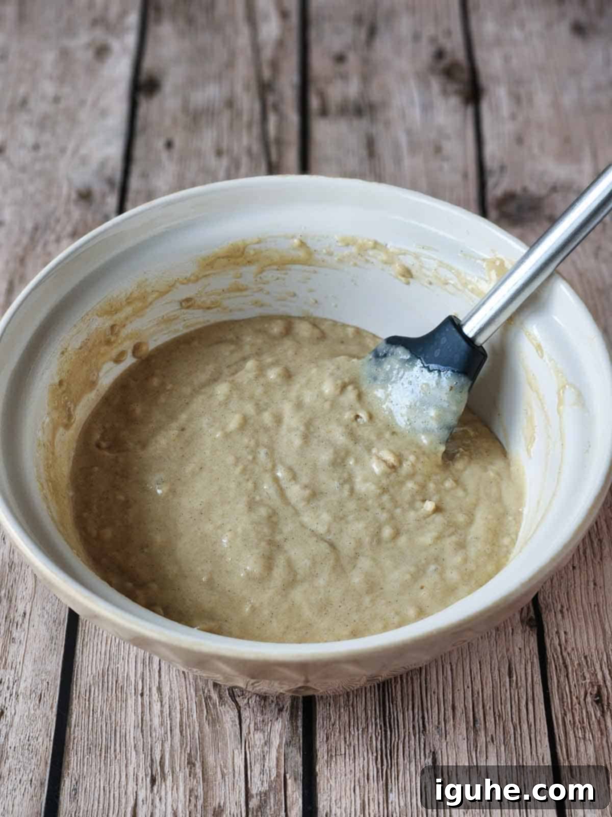 Golden Chocolate Chip Loaf 7 Cake batter in a beige bowl with a spatula in it.
