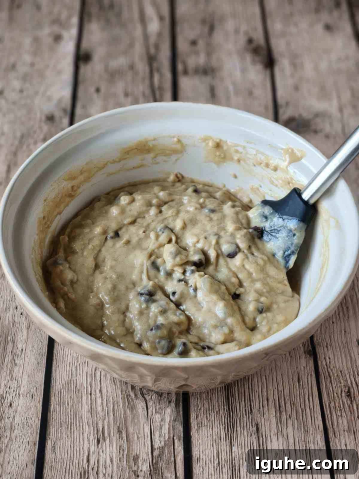 Golden Chocolate Chip Loaf 8 Cake batter with chocolate chips in a beige bowl.