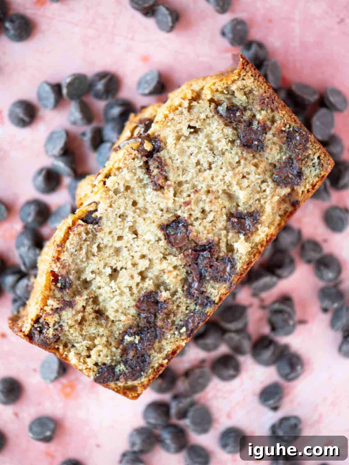 Golden Chocolate Chip Loaf 10 Overhead showing a slice of chocolate chip cake over chocolate chips.