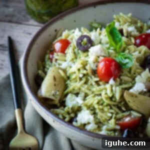 Vibrant Pesto Orzo Bowl 8 Close up of a vibrant Orzo Pesto Salad in a beige bowl, resting on a wooden surface.