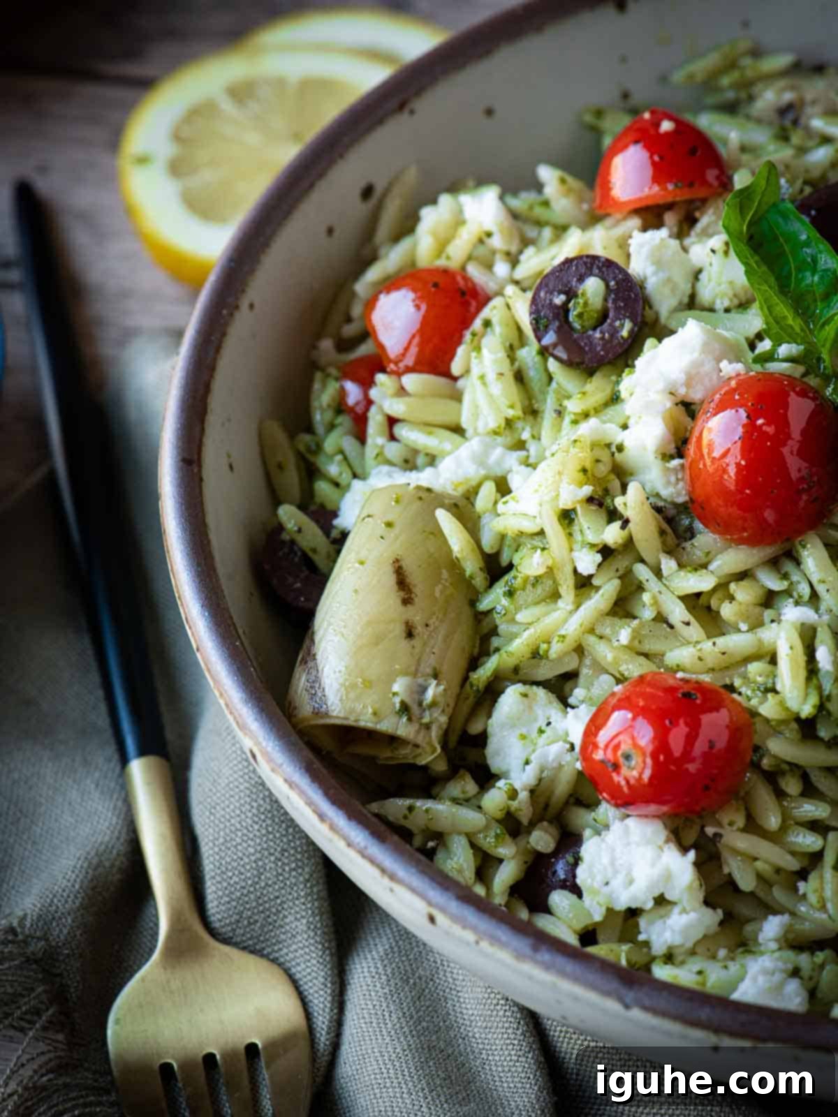 Vibrant Pesto Orzo Bowl 7 Angled close-up of Orzo Pesto Salad, with fresh pesto and cherry tomatoes visible, and a fork resting beside the bowl, ready to be enjoyed.