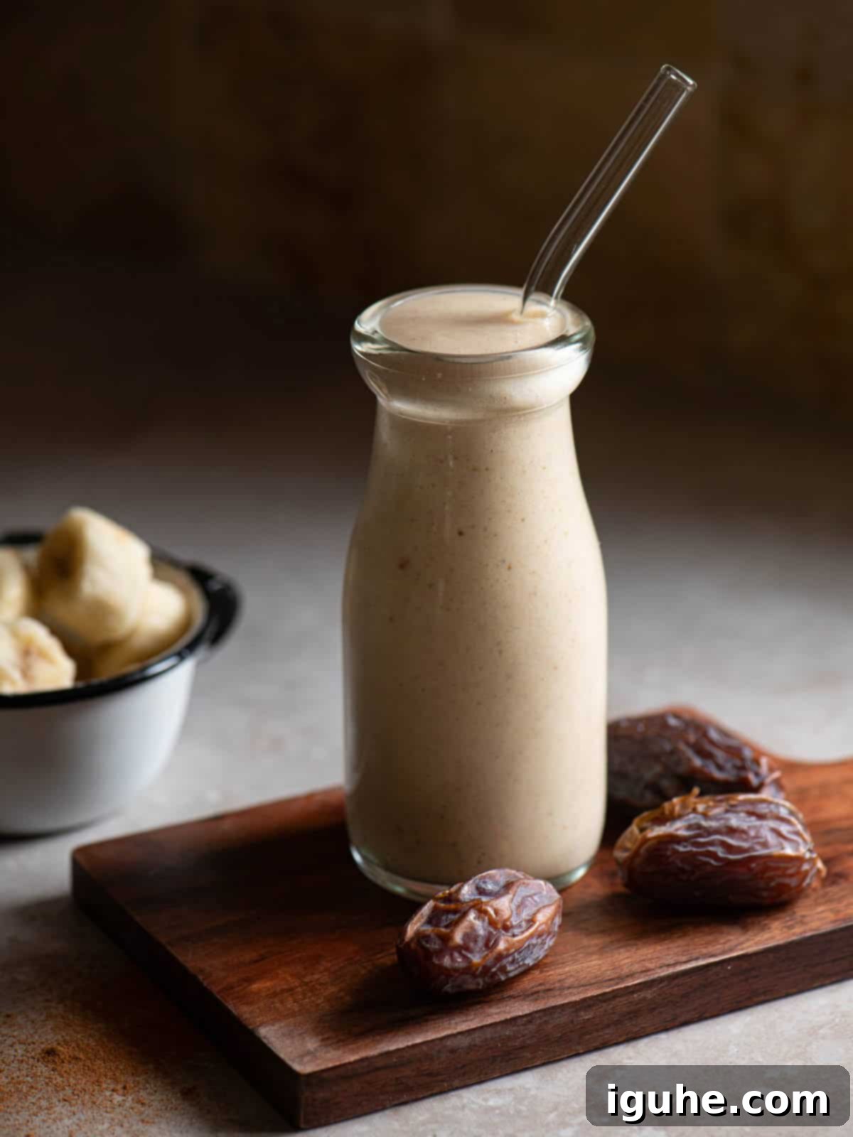 Velvet Banana Date Delight 5 Date smoothie in a clear glass with a clear straw.