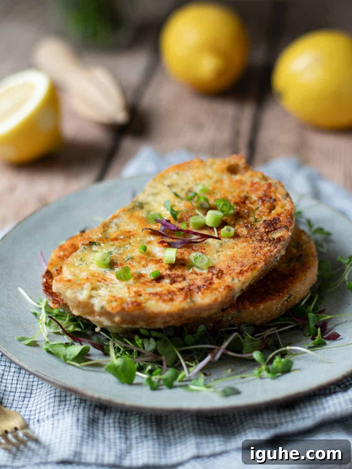Angled view of savory French toast on grey plate with lemons in the background.